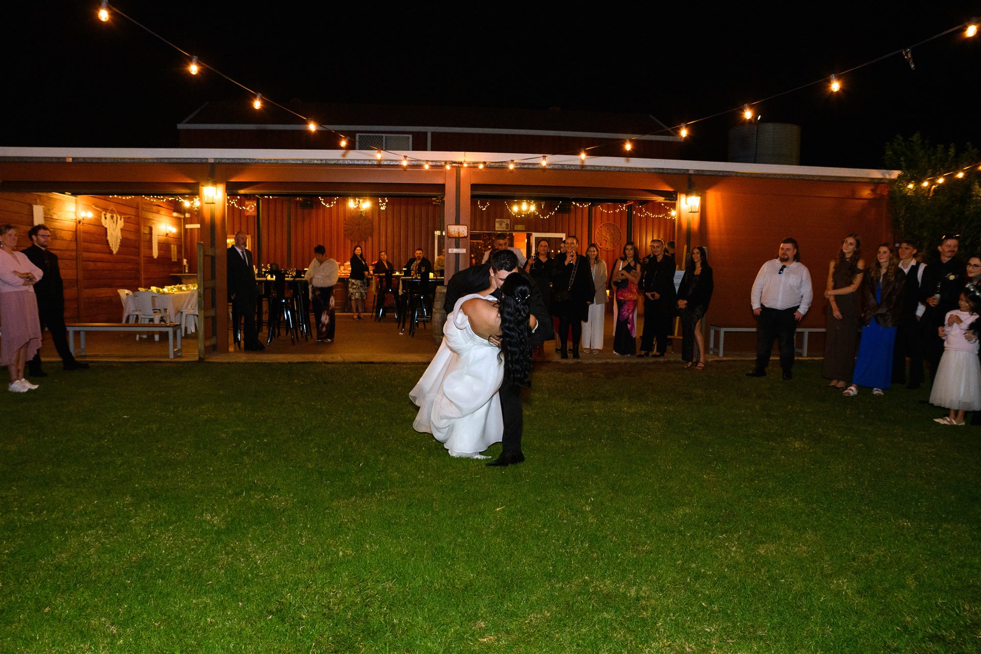 First dance on the lawn at night in front of the glowing barn