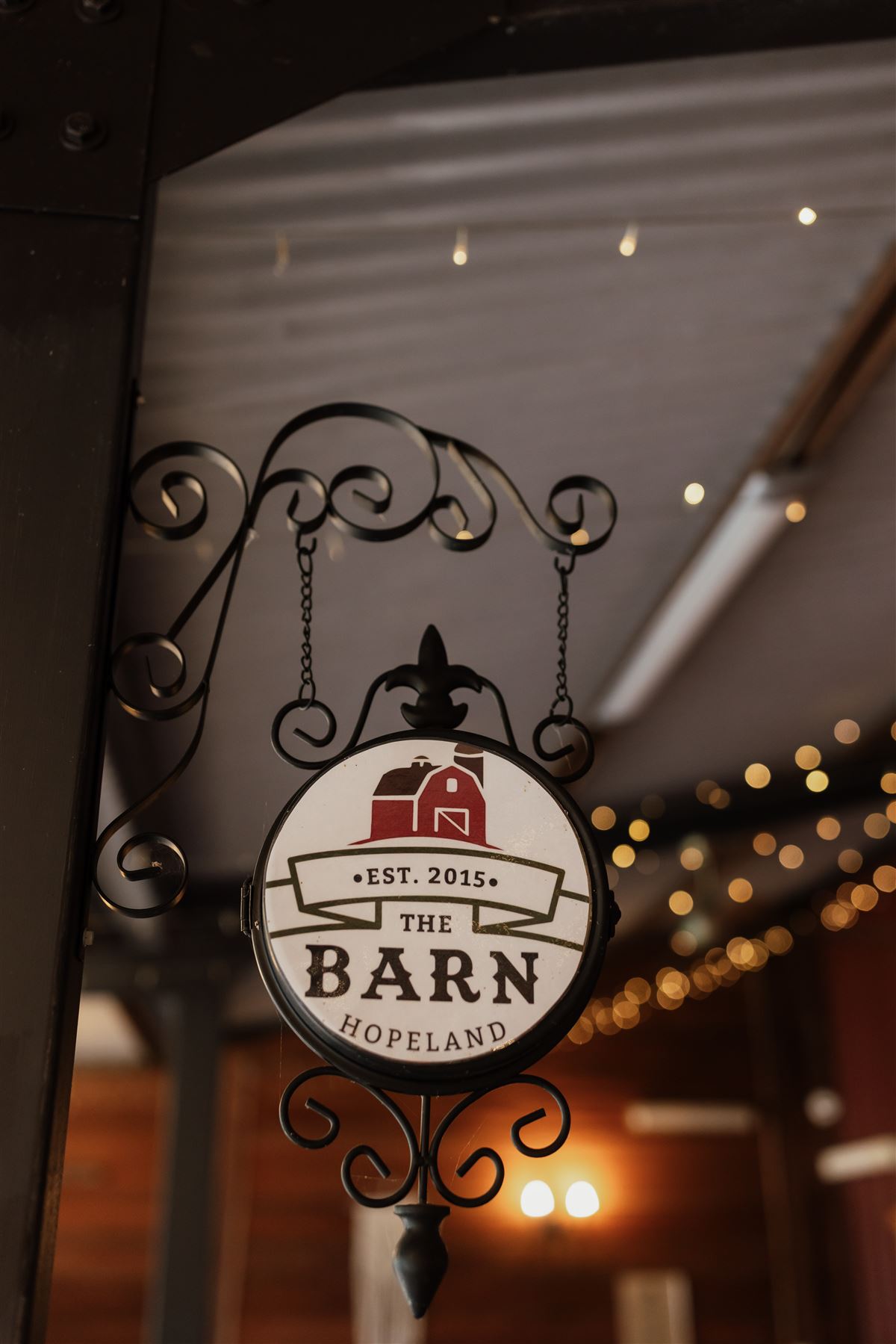 Close-up of the hanging The Barn Hopeland est. 2015 sign