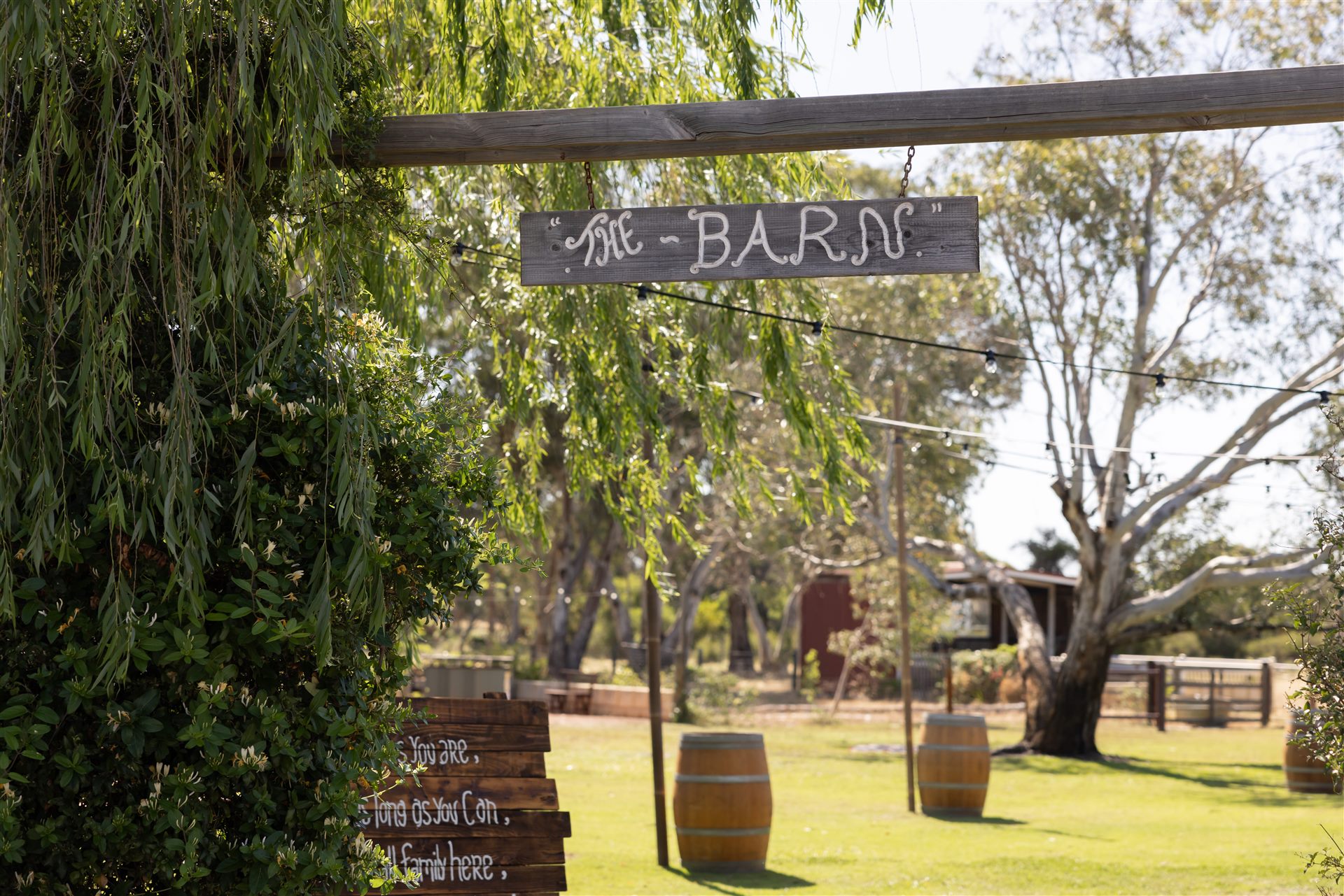 The Barn entry sign with wine barrels on the lawn